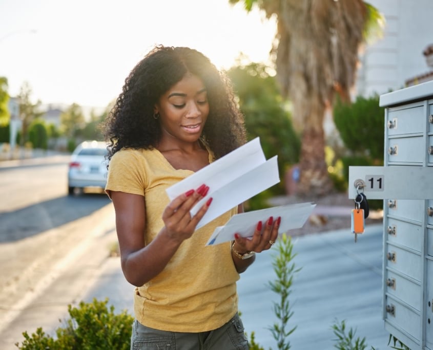 Crush Your Revenue Goals With a Direct Mail Campaign woman checkin her mailbox web