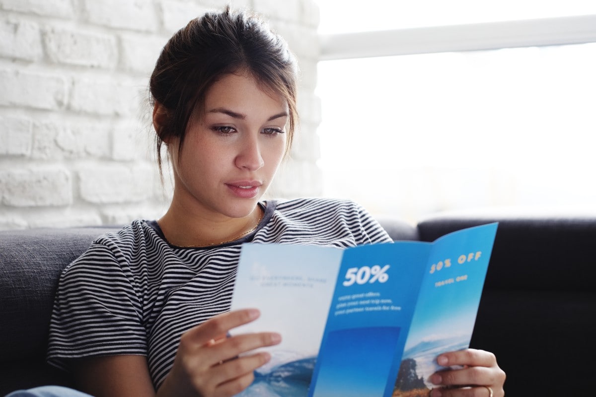 effective direct mail campaigns woman reading a flyer web
