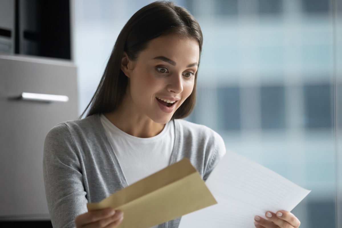 millenial woman excited opening mail web 1