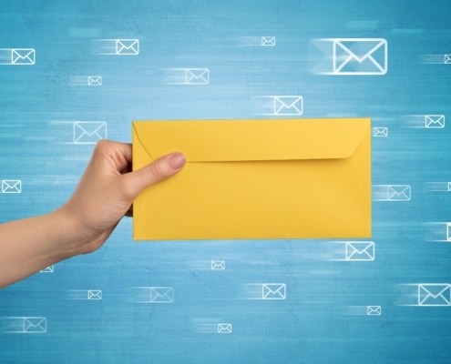 Direct mail performance metrics Hand holding yellow envelope web