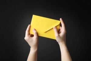 DIRECT MAIL MARKETING ENVELOPES hands holding yellow envelope