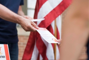 person handing out printed campaign materials